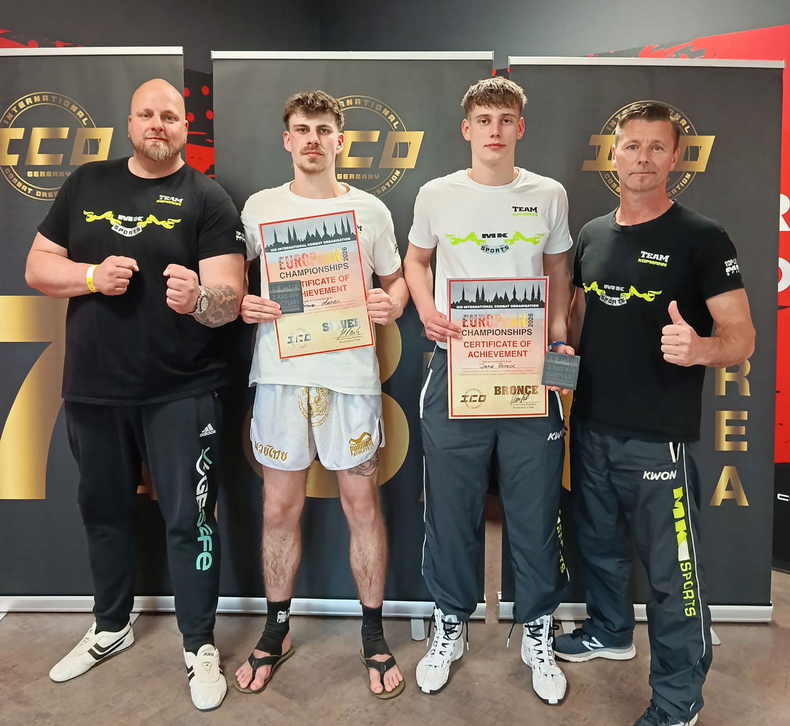 zeigt Norman Auras und David Raseck mit Wettkampfurkunden sowie 2 Boxtrainer