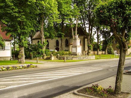 zeigt Blick über die Dorfstraße auf die Kirche und das Ehrenmal zum Gedenken der Kriegsgefallenen